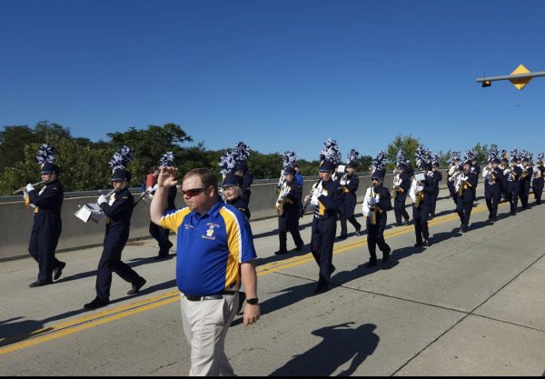 Band director Mr. Roble leads the marching band during a parade. 